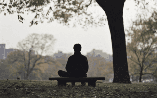 Personne assise en position de yogi sur un banc