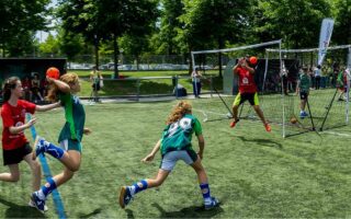 "Enfant souriant tenant un ballon de football, illustrant le soutien parental dans le sport"