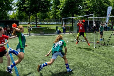 "Enfant souriant tenant un ballon de football, illustrant le soutien parental dans le sport"